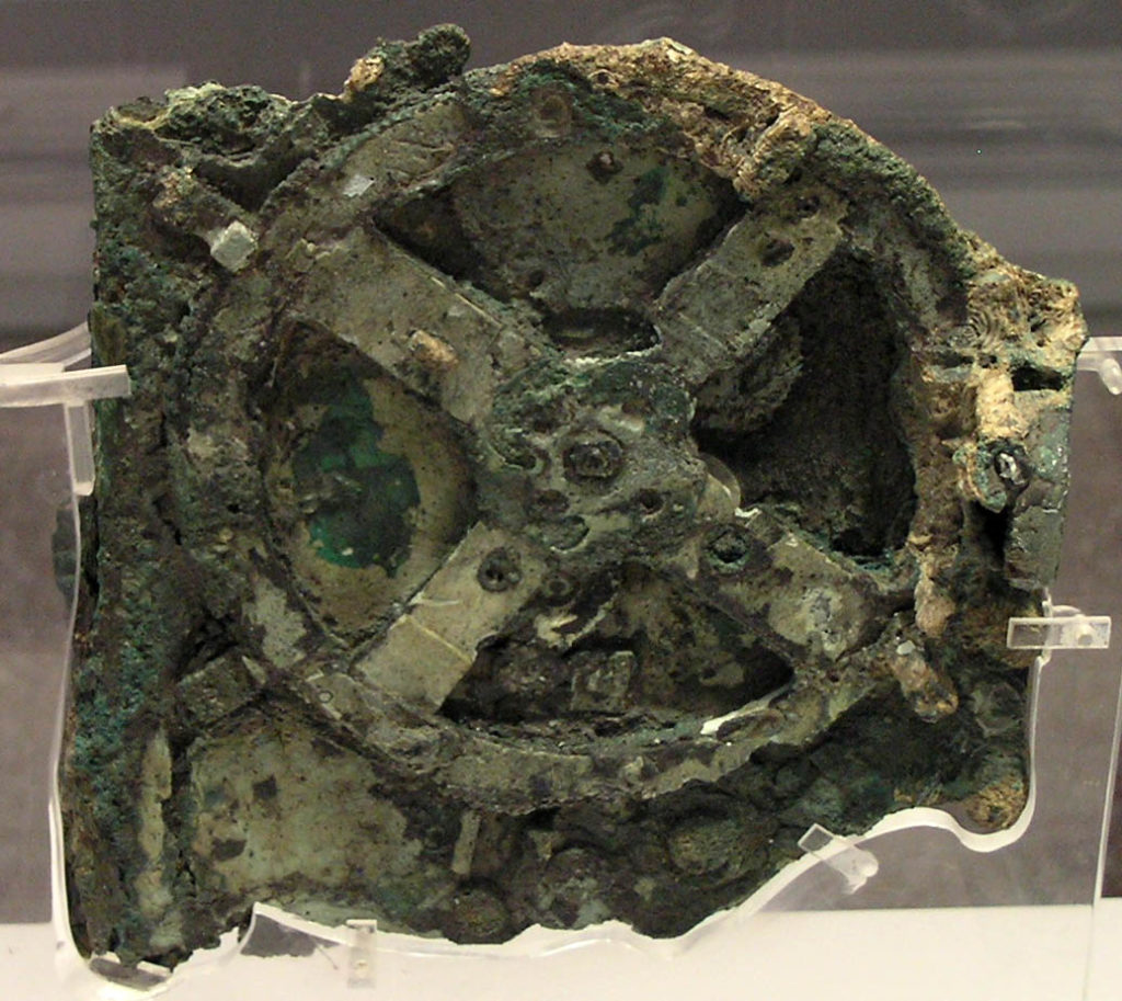 The Antikythera mechanism (Fragment A – front and rear); visible is the largest gear in the mechanism, approximately 13 centimetres (5.1 in) in diameter.
